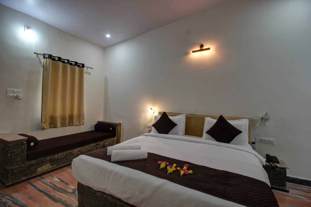 Takhat Villa Super Deluxe room with king bed and Aravalli hill views